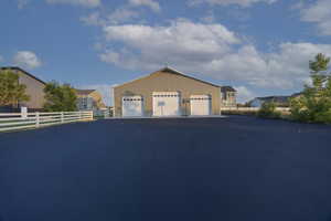 View of front of property with a detached garage and an outbuilding