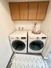 Laundry room featuring cabinet space, washer and clothes dryer, and baseboards