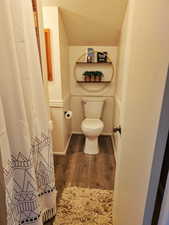 Bathroom with dark wood-style flooring, a textured ceiling, and a shower with shower curtain