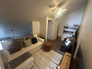 Upstairs living room with ceiling fan and vaulted ceiling