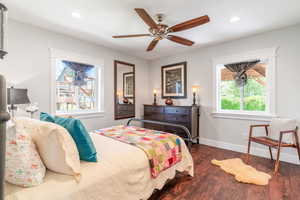 Bedroom with dark wood finished floors, baseboards, recessed lighting, and a ceiling fan