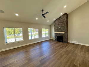 Great room featuring high vaulted ceiling, a fireplace, a ceiling fan, recessed lighting and tons of natural light