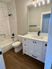 Full bath with vanity, quartz countertop, bathtub / shower combination. Tile all the way up to the ceiling surrounding the tub.