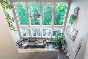Living area with wood finished floors, a ceiling fan, healthy amount of natural light, and baseboards