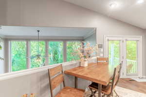 Dining space with vaulted ceiling, light wood-type flooring, ornamental molding, and recessed lighting