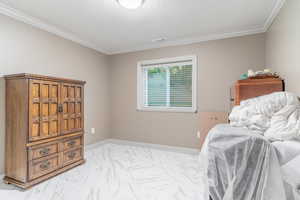 Bedroom featuring light marble finish floors and ornamental molding