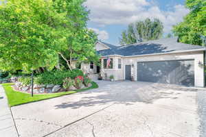 Ranch-style home featuring a garage, concrete driveway, and brick siding