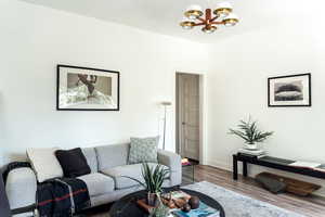 Living area featuring a chandelier, wood finished floors, and baseboards