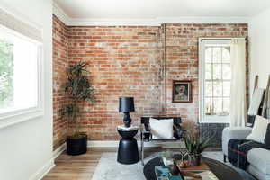 Living room featuring baseboards, wood finished floors, healthy amount of natural light, and crown molding