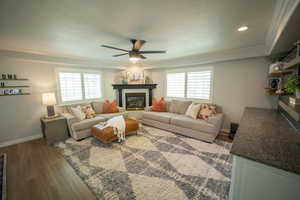 Beautiful Living room featuring plenty of natural light, wood LVP floors, a gas fireplace, and ornamental molding