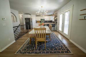 Spacious dining space with a custom dining chandelier and french doors out to deck.