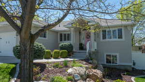 View of front of house with stucco siding, an attached 2 car garage, with RV parking on East side.