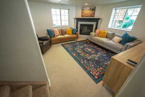 Living room featuring carpet flooring, a tiled fireplace, and recessed lighting and DAYLIGHT WINDOWS!