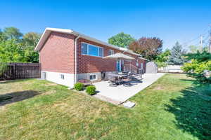 Rear view of property with brick siding and a patio area