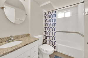 Full bathroom featuring toilet, vanity, and shower / tub combo with curtain