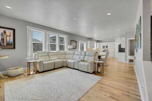 Living area with light wood finished floors, recessed lighting, and baseboards