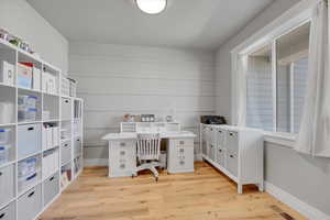 Office area featuring light wood-style floors and baseboards