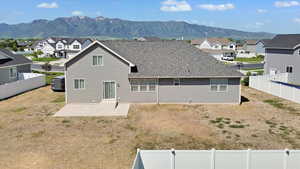 Back of house featuring a patio area, a residential view, a mountain view, and a fenced backyard