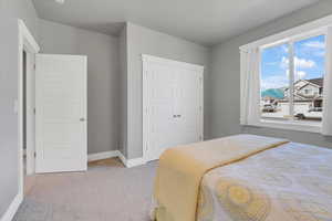 Bedroom with a closet, carpet, and baseboards