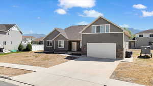 Craftsman inspired home featuring a mountain view, concrete driveway, an attached garage, and central AC