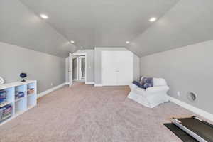 Living area featuring vaulted ceiling, carpet floors, recessed lighting, and baseboards