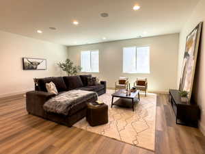 Living room with recessed lighting, wood finished floors, plenty of natural light, and baseboards