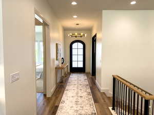 Foyer with plenty of natural light, dark wood finished floors, recessed lighting, and a chandelier
