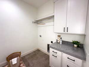 Laundry room featuring cabinet space, hookup for a washing machine, electric dryer hookup, and baseboards