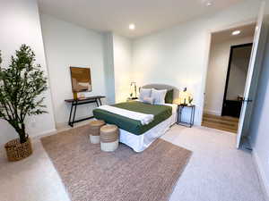 Bedroom with light carpet, recessed lighting, and baseboards
