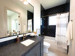 Full bathroom featuring toilet, vanity, shower / bath combo, and tile patterned flooring