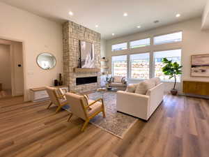 Living room featuring light wood-type flooring, a fireplace, and recessed lighting
