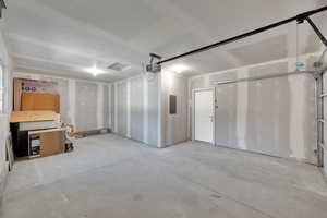 Garage featuring electric panel and a garage door opener