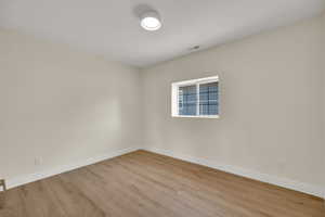 Empty room featuring wood finished floors and baseboards