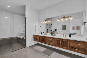 Bathroom featuring double vanity, tile patterned flooring, a relaxing tiled tub, tiled shower, and recessed lighting