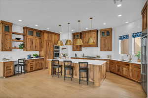 Kitchen with stainless steel appliances, brown cabinets, a sink, and recessed lighting