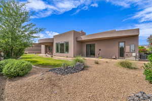 Back of property featuring stucco siding, central air condition unit, and a yard