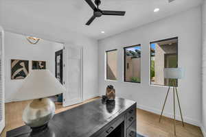 Office area featuring a ceiling fan, light wood finished floors, recessed lighting, baseboards, and a chandelier