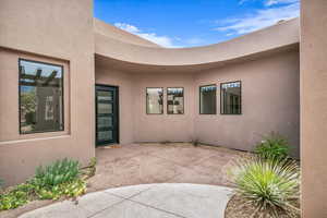 Doorway to property featuring a patio area and stucco siding
