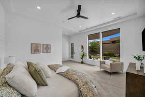 Bedroom with light carpet, recessed lighting, ceiling fan, a tray ceiling, and baseboards