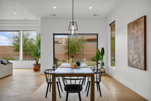 Dining room featuring healthy amount of natural light, recessed lighting, wood finished floors, and baseboards