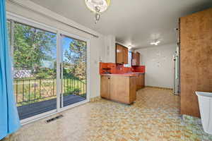 Kitchen with a peninsula, plenty of natural light, and freestanding refrigerator
