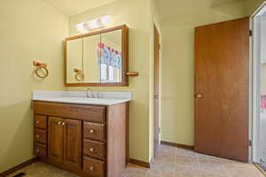 Bathroom featuring vanity, baseboards, and tile patterned floors