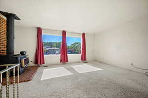Carpeted living room with a wood stove