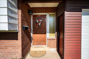 Property entrance featuring brick siding