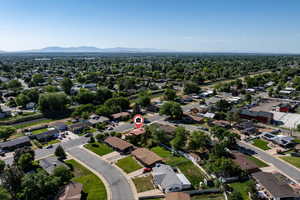 Aerial view of property and surrounding area with nearby suburban area and a mountainous background