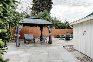 Fenced backyard featuring a gazebo, a patio, and outdoor lounge area