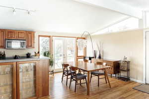 Dining area with light wood-style floors, rail lighting, french doors, and baseboards