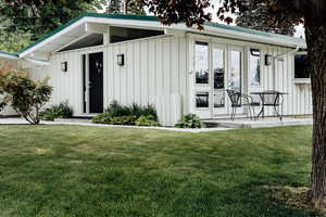 View of front of home featuring board and batten siding and a front yard