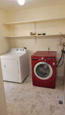 Laundry area featuring washing machine and clothes dryer and light tile patterned floors