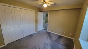 Unfurnished bedroom with carpet, a closet, and baseboards